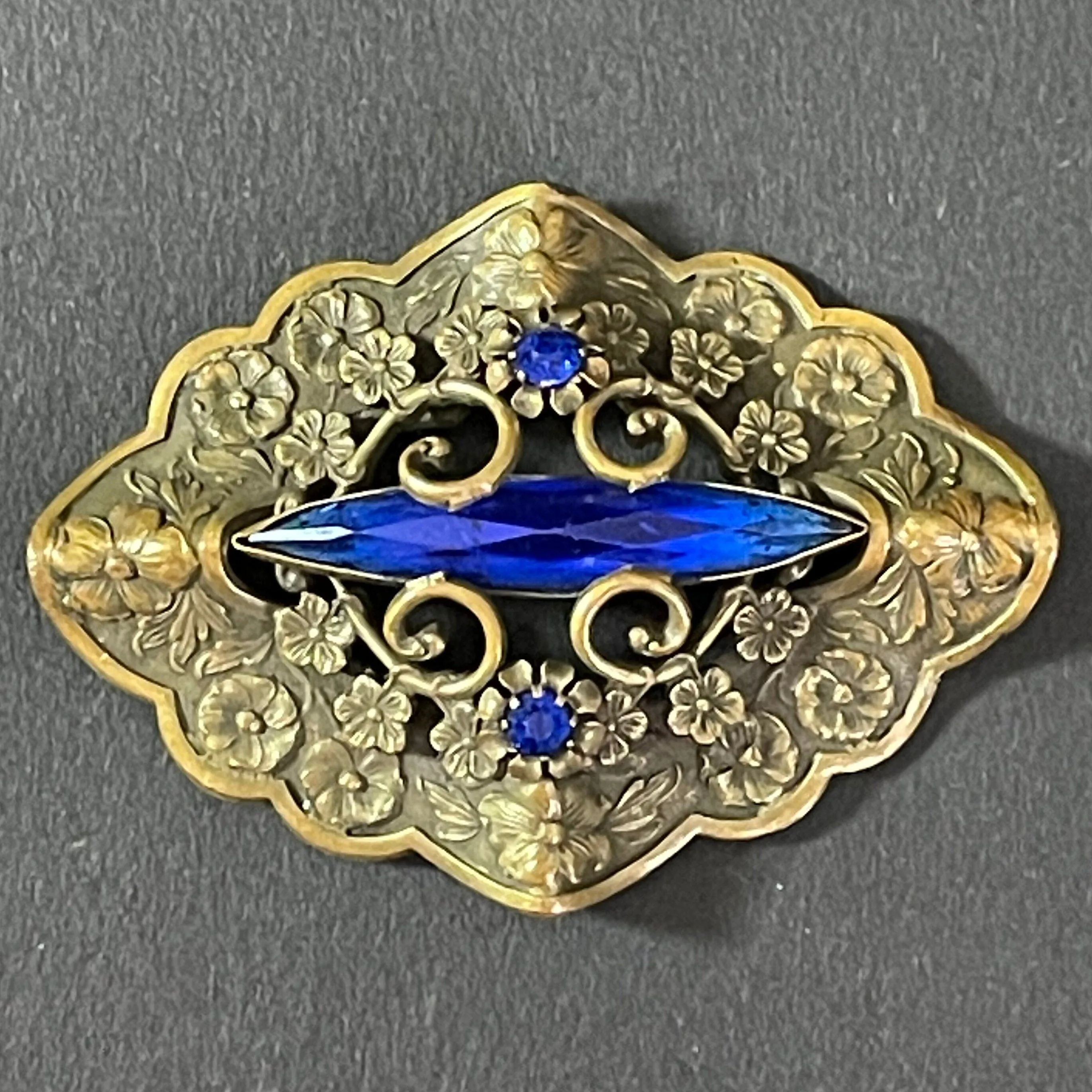 Large vintage Art Nouveau to Art Deco sapphire blue rhinestone & ornate gold tone three dimensional floral design Czech brooch, Neiger style