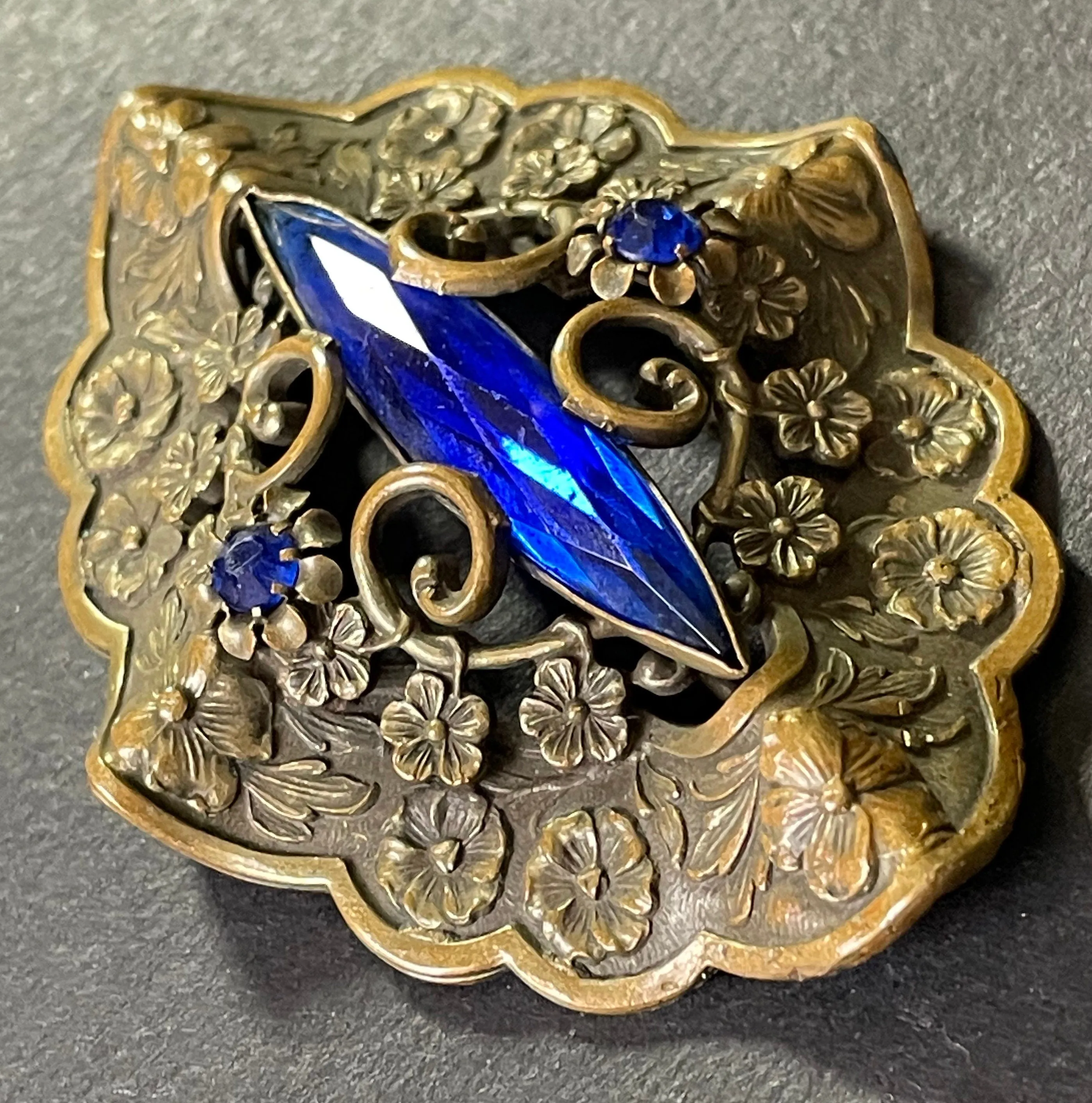 Large vintage Art Nouveau to Art Deco sapphire blue rhinestone & ornate gold tone three dimensional floral design Czech brooch, Neiger style