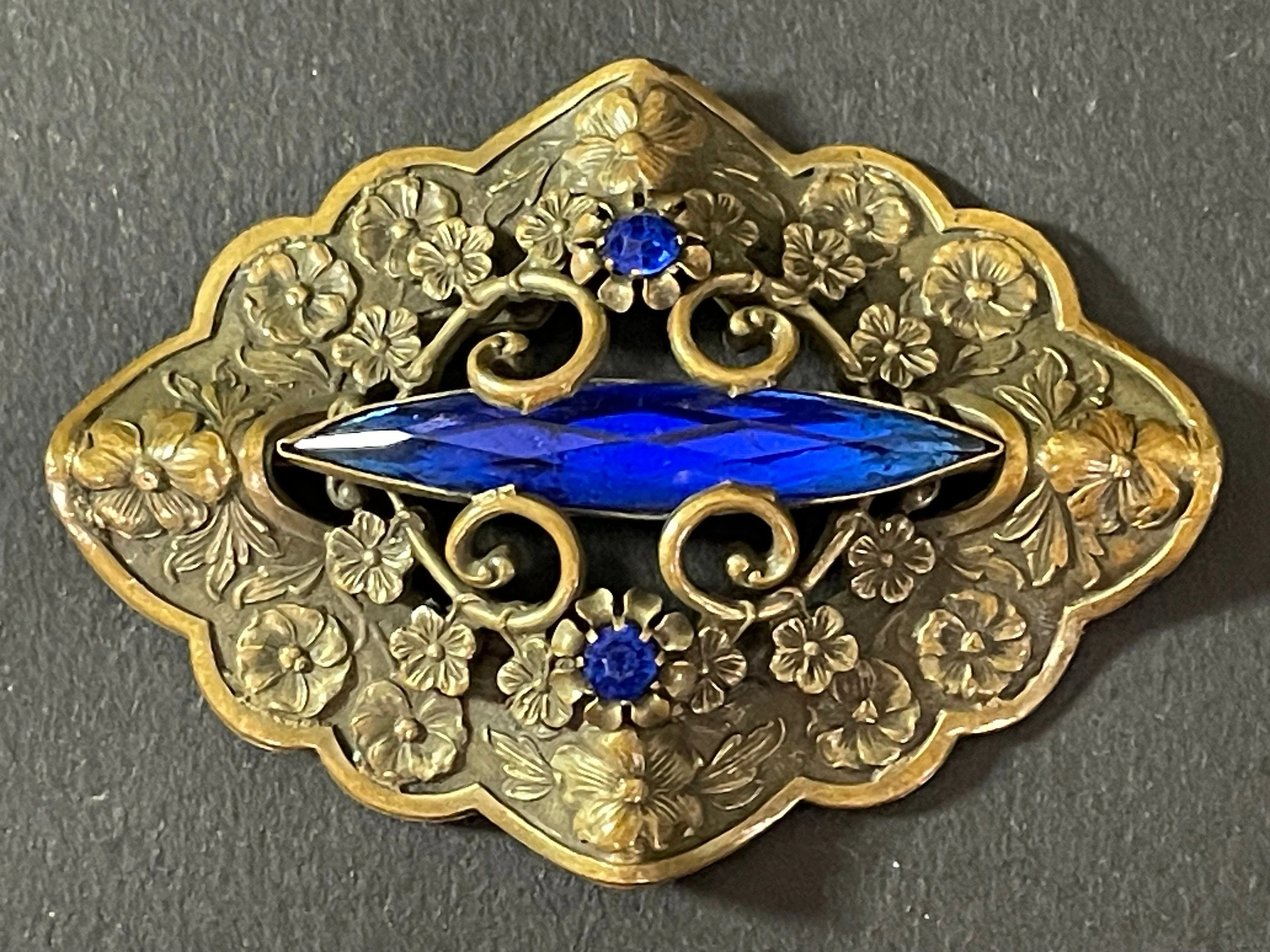 Large vintage Art Nouveau to Art Deco sapphire blue rhinestone & ornate gold tone three dimensional floral design Czech brooch, Neiger style